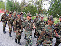 Acemi birliğinde tüfekleri omuzlarında uygun adım yürüyen askerler