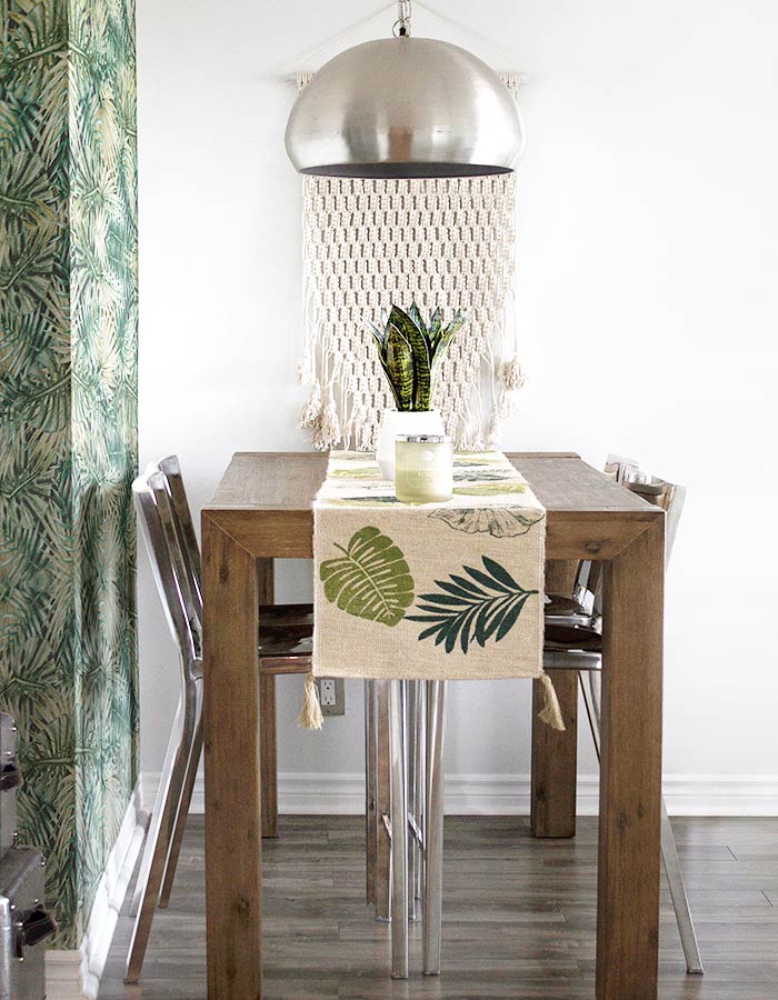 Sala de jantar em estilo de decoração escandinava e pendente metálico redondo sobre a mesa de jantar