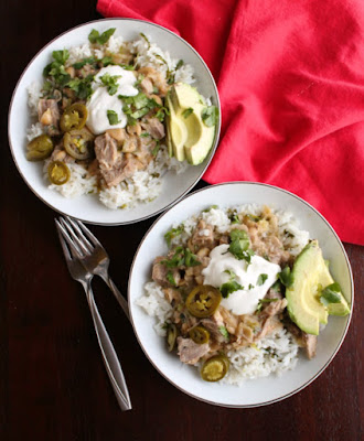Pork and salsa verde go so well together. Bring them together in this simple instant pot meal that is delicious served over rice for burrito bowls. salsa verde pork burrito bowls with sour cream, jalapenos, cilantro and slices of avocado
