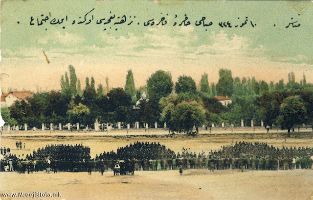 Полигонот на Третата турска армија, за вежби на војската. На истата се гледаат гледачи на три бините, пред смотра на војската. Во заднината е Железничката улица и паркот “Nuzhetiye” зад оградата, кој беше наречен Парк на слободата по 1908 година. Во средината на сликата се гледа и киоскот помеѓу дрвјата.