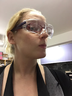 female in goggles, glasses, and apron