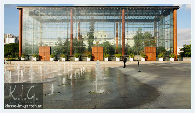 Eines der beiden Glashäuser im Parc Andre Citroen, im Vordergrund die auf und absteigenden Wasserfontänen-