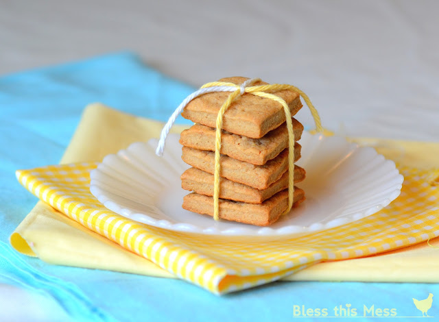 A stack of thick graham crackers tied together with string on top of a white plate.