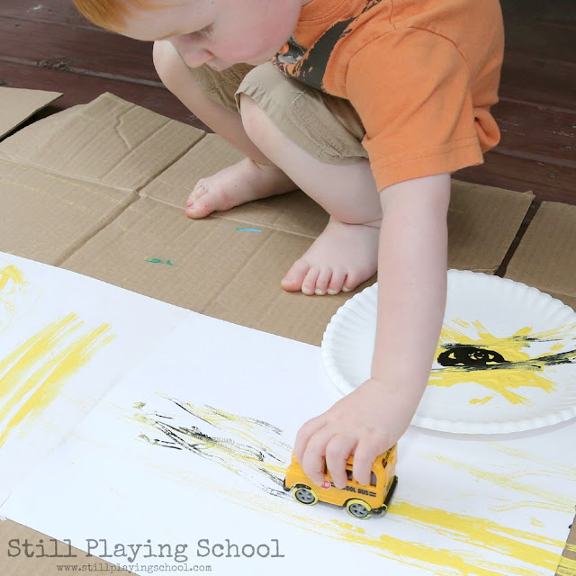 Toddler process art painting with school bus
