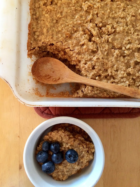 Baked peanut butter oatmeal in a serving bowl topped with blueberries.