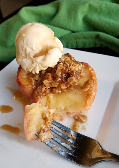 The perfect individual sized dessert, these mini apple crisp baked apples are the perfect mix of baked apples and crisp topping. Serve it with a scoop of ice cream for a perfect dessert! apple crisp baked apple with bite on fork and scoop of vanilla ice cream