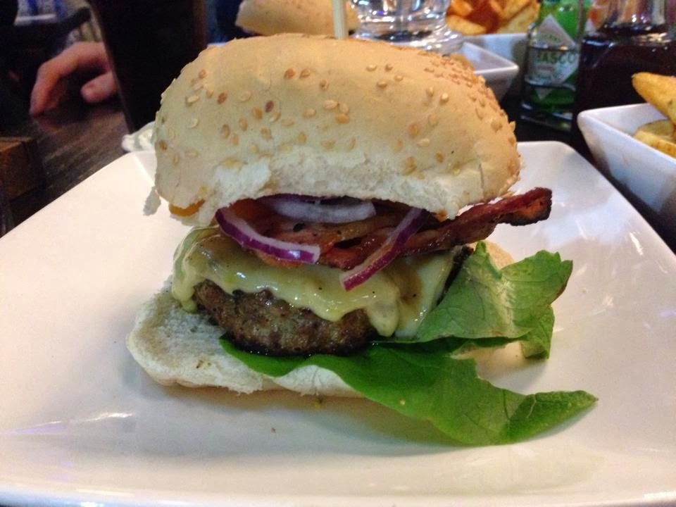 a close up shot of a large burger on a plate