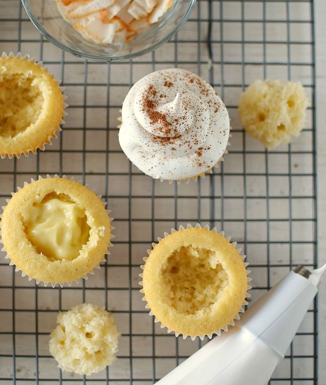 Los cupcakes de vainilla se rellenan con una crema de coco y se decoran con merengue