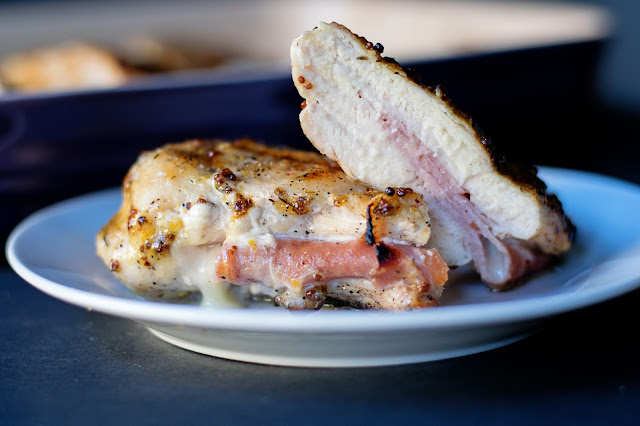 The finished Grilled Chicken Cordon Bleu, cut in half, on a plate, so you can see what the inside looks like. 