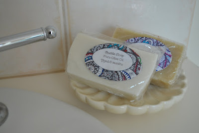Two soaps displayed on a scalloped dish on my bathroom benchtop. A tap can be seen in the top left corner.