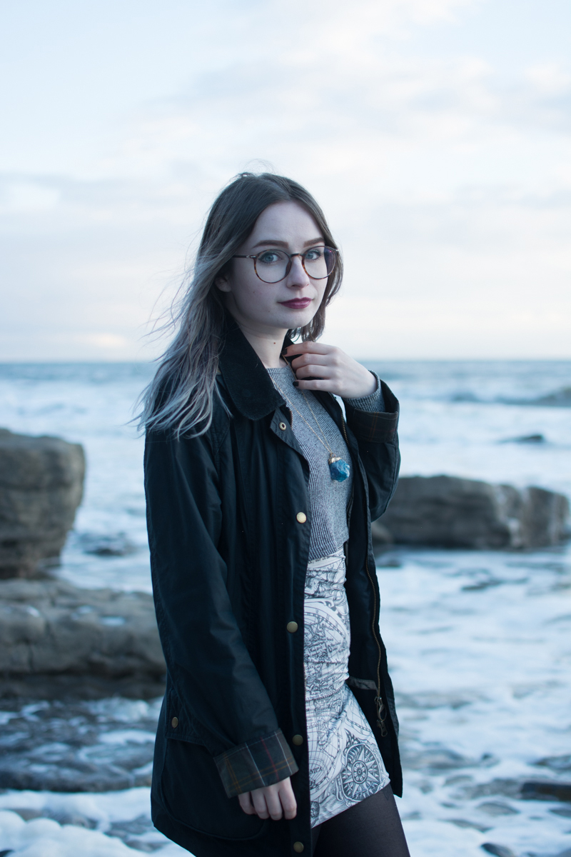 portrait of a girl on the beach long sleeve crop top black milk ancient maps bodycon dress big hipster glasses crystal necklace