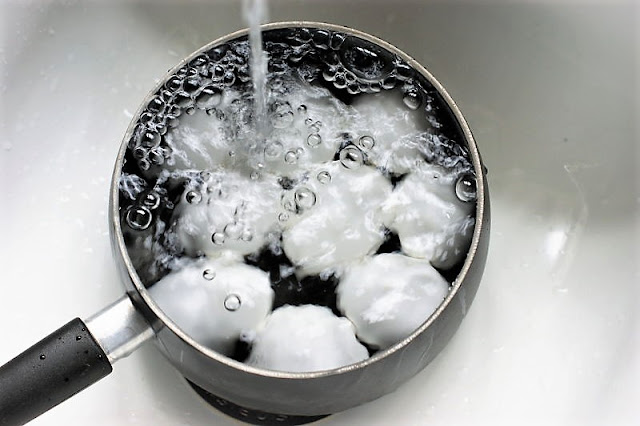 Running Hard Boiled Eggs Under Cold Water to Cool Image