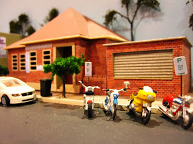 Quarter inch scale modern Australian town street scene with council building and motorcycles parked outside.