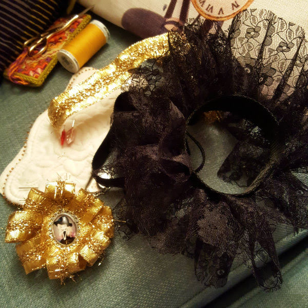Finished rosette and cuff, just needs fixed together gold rosette sitting alongside black lace cuff and other sewing materials