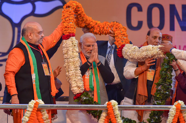 Prime Minister Narendra Modi being garlanded by BJP President Amit Shah on the first day of the two-day BJP National Executive Meet, at Ramlila Maidan in New Delhi 