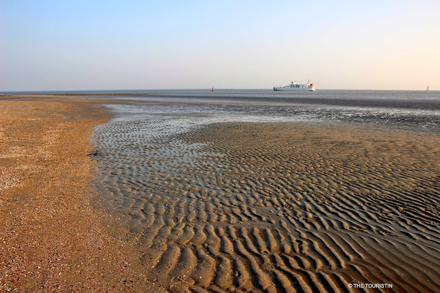 UNESCO heritage listed Wadden sea with a passenger ferry in the distance.
