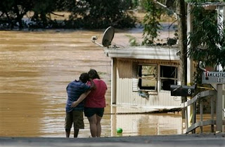 Jennifer Bozeman, 19, and Nabor Torres stand at the edge of Sweetwater Creek after it overflowed its banks and left the mobile home park where they live flooded Tuesday, Sept. 22, 2009, in Austell, Ga. (AP Photo/John Amis) 