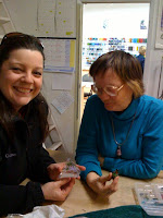 Janine inspects Liz's paperweights