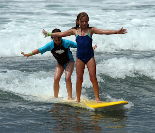 After these two campers learned to surf at Aloha Beach Camp, they shared a board and learned tandem surfing, too!