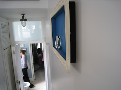 Side view of a shadow box made by Shannon Cockrell hung on a wall in her London flat