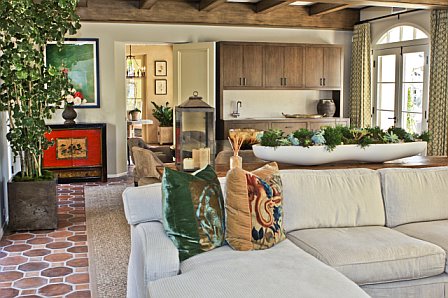 Garage was turned into a media room after remodeling with natural wood beamed ceiling, spanish tile floor, white sofa and a flat screen TV