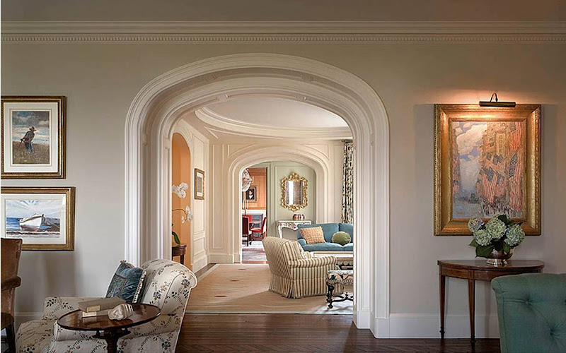 Succession of bright, white painted arched entryways with molding and 