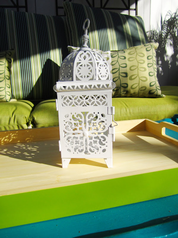 White metal Moroccan lantern on a bright green tray 