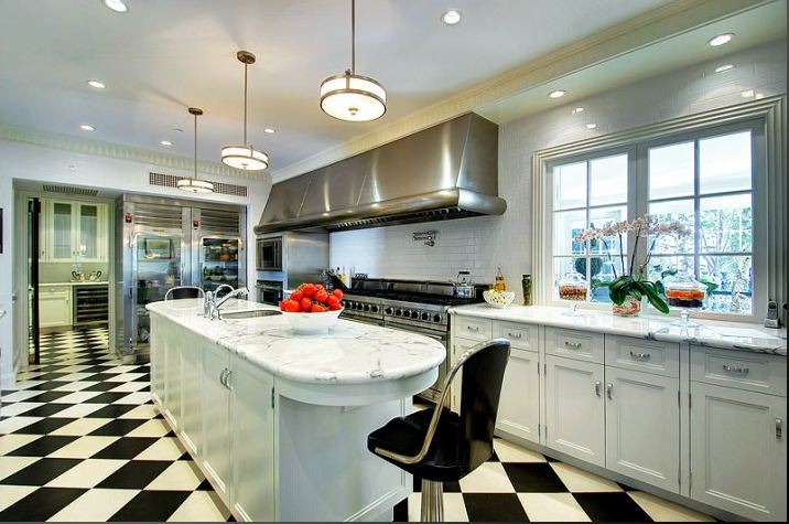 Gourmet kitchen in a Paul Willims designed home with state of the art appliances, custom cabinetry, Carrera marble counters and wonderful black and white checkered floor