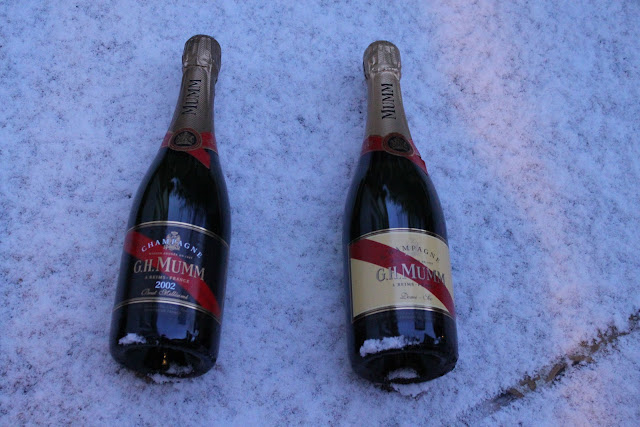 Mumm champagne being kept cold on a snowy balcony.