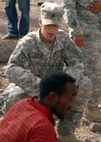 Spc. Samuel Rasmussen, Joint Combat Search and Rescue security team rifleman, Bravo Battery, 2nd Battalion, 18th Field Artillery Regiment, renders first aid to an injured civilian at the scene of a vehicle accident in Djibouti June 24, 2008. (RELEASED) Photo by Air Force Tech Sgt. Katherine Garcia.