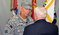 U.S. Defense Secretary Robert M. Gates takes the Multi-National Force Iraq flag from Army Gen. Raymond Odierno during the MNF-I change of command on Camp Victory, Iraq, Sept. 16, 2008.