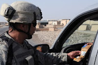 Staff Sgt. Paul Cruz checks a driver's identification at a checkpoint outside Baghdad. Since U.S. troops pulled out if Iraqi cities, attacks in the Iraqi capital have been on the decline.