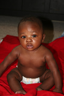 Infant baby boy sitting on a blanket