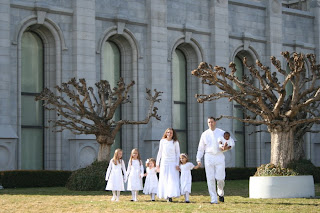 Family with 4 girls and 1 boy modeling outside of a church 