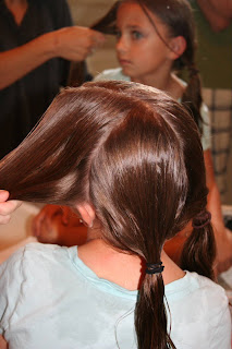 Back view of girl's hair being styled in "Criss-Cross French Braids"