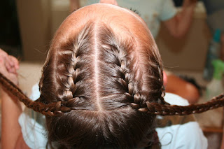 Top view of girl's hair being styled in "Criss-Cross French Braids"