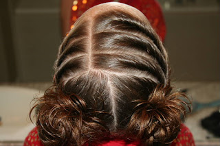Top view of young girl's hair styled into "Triple Twists and Messy Buns"