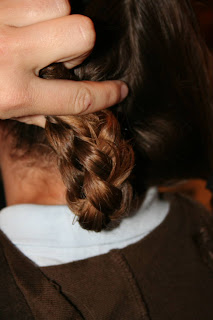 Back view of young girl's hair being styled into "Double-French Braids w/Messy Flips"