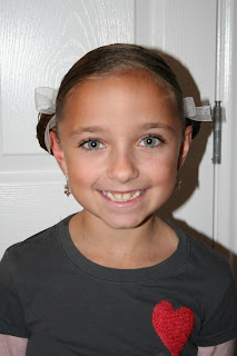 Portrait of young girl modeling "Basic Twisty Buns" hairstyle