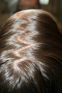 Top view of young girl's hair being styled into "Basic Twisty Buns" hairstyle