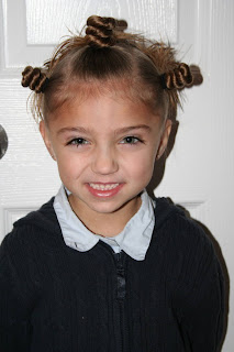 Portrait of young girl modeling "Holiday Twisty Buns" hairstyle