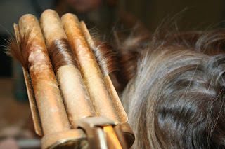 close up view of young girl's hair being styled into 3-barrel curl hairstyle on her a-line bob