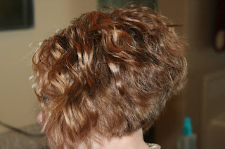 side view of young girl modeling 3-barrel curl hairstyle on her a-line bob