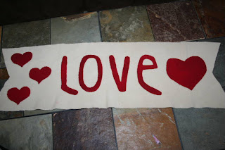 Large white banner with the word "love" on it surrounded by hearts