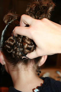 Back view of young girl's hair being styled into "bundled braids" hairstyle