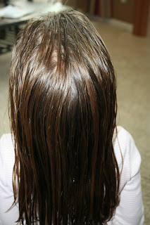 Back view of young girl's hair being styled into "The Bun-Hawk" hairstyle