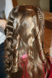 Back view of young girl's hair being styled into "Beachy Combo" hairstyle 