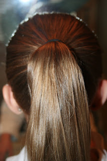 Back view of young girl's hair being styled into "Three-Leaf Clover Twists" hairstyle