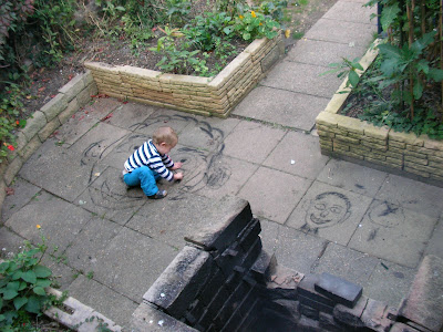 pavement artist drawing faces in charcoal on the patio