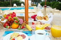 Desayuno con frutas y jugos naturales junto a la piscina de Barramar Pousada